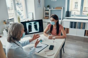 doutora conversando com paciente mostrando raio x