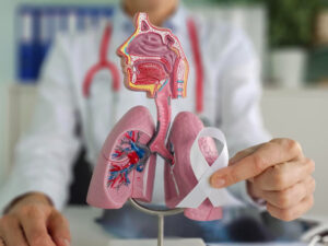 medico explicando câncer de pulmão com fita branca