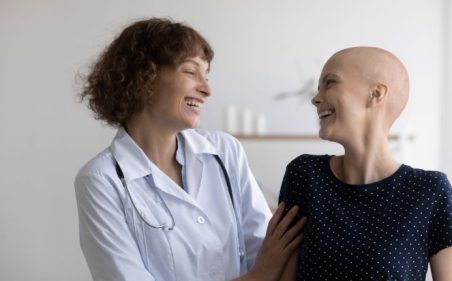 Médica conversa com paciente em ambiente clínico durante acompanhamento do tratamento