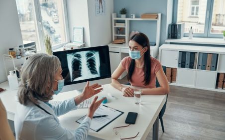 doutora conversando com paciente mostrando raio x